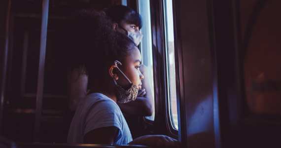 girl and woman looking out the window of a subway